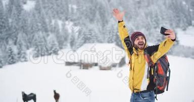 微笑的大青年游客在一个冬天的日子里在山中旅行，他来到了一个乡村带着